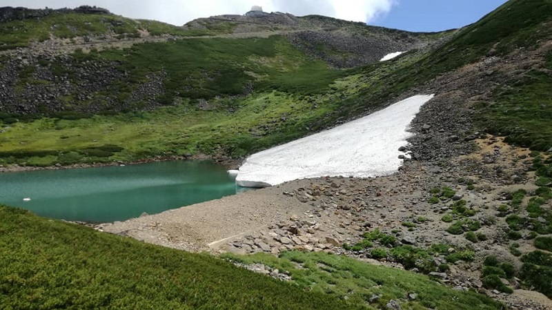 剣ヶ峰へと続く遊歩道から見える不消ヶ池もきれいなエメラルドグリーンと雪渓、癒されます