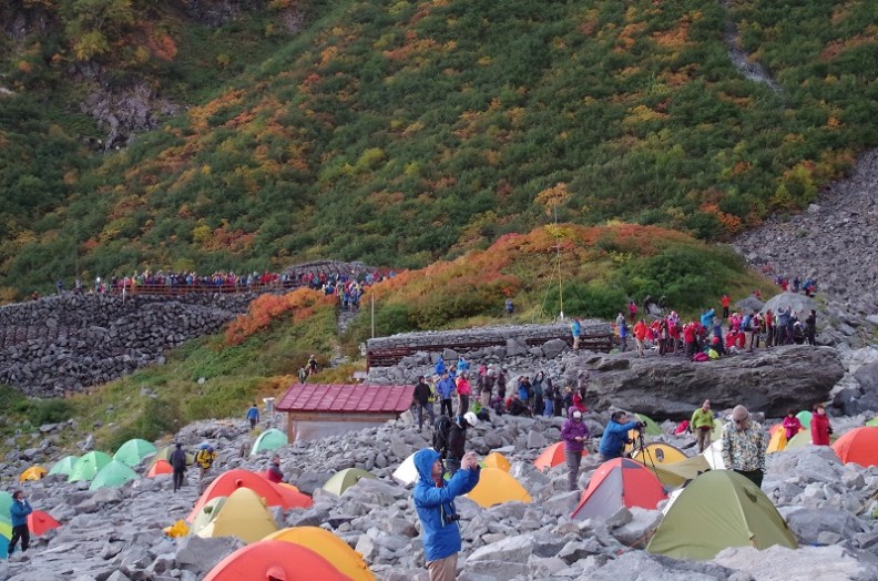 赤く焼ける涸沢を撮影する多くの登山者